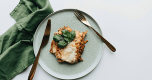 A plate on the table with food and spoon on it