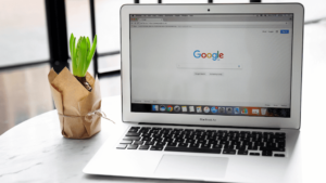 A laptop on the table and a with a screen display Google